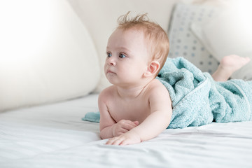 Wall Mural - Portrait of beautiful baby boy after having bath lying on bed in bedroom