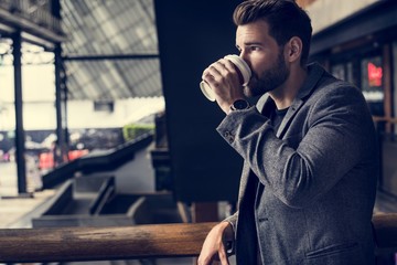 Side view of mna drinking hot coffee