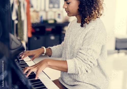 Woman playing on a piano Tablou Canvas