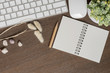 Top view of white keyboard, mouse, blank notebook, pencil and houseplant on wooden table