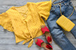 Womens clothing, accessories, shoes (yellow blouse in polka dot, blue jeans, leather red sandals,  yellow crossbody bag). Fashion outfit. Shopping concept. Flat lay. Spring summer collection