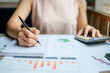 © Jo Panuwat D - Businesswoman analysis maketing plan, Accountant calculate financial report, with graph chart.  Business, Finance and Accounting concepts