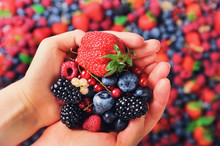 Woman Hands Holding Organic Fresh Berries Against The Background Of Strawberry, Blueberry, Blackberries, Currant, Mint Leaves. Top View. Summer Food. Vegan, Vegetarian And Clean Eating Concept.