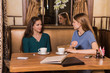 © Smile - Two happy women drinking coffee in cafe