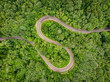 Winding curved road in the middle of the forest. Aerial shot using a drone