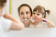 © Oksana Kuzmina - mother teaching child daughter teeth brushing in bathroom