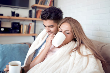 Sticker - Young couple relaxing on a sofa and having coffee