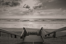Scenic Biscarrosse Beach In Sunset With Clouds And Wooden Footpath Stairs In Black And White Sepia, France