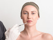 © madeinitaly4k - Expert beautician injecting botox in female face.