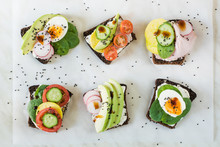 Different Sandwiches With Vegetables, Eggs, Avocado, Tomato, Rye Bread On Light Marble Table. Top Vew. Appetizer For Party. Flat Lay.