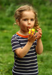 © Free_styler - Close up portrait of a toddler girl blowing a toy wooden whistle outdoors