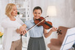 Basics of violinist. Competent tutor standing in semi position while teaching her student