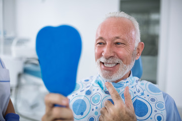 Dentist with sterile mask and dental instruments held exam teeth of patient