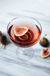 © Myrthe - Summer cocktail aperitif with figs on a marble table.