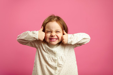 Funny shot of little girl with her thumbs up