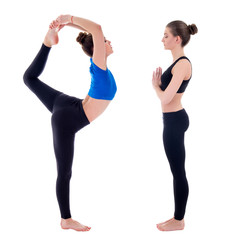 Wall Mural - side view of two young slim women doing yoga isolated on white