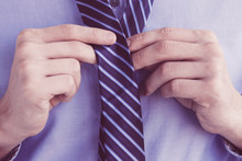 Cropped View Of Business Man Tying His Necktie. Isolated View On White Background.