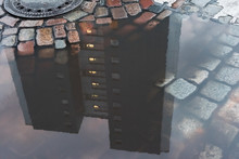 A House Made Of Concrete Mirrored In The Puddle