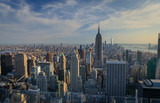 Fototapeta  - Manhattan downtown skyline with illuminated Empire State Building and skyscrapers at sunset