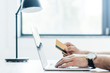 © LIGHTFIELD STUDIOS - cropped shot of person holding credit card and using laptop at workplace