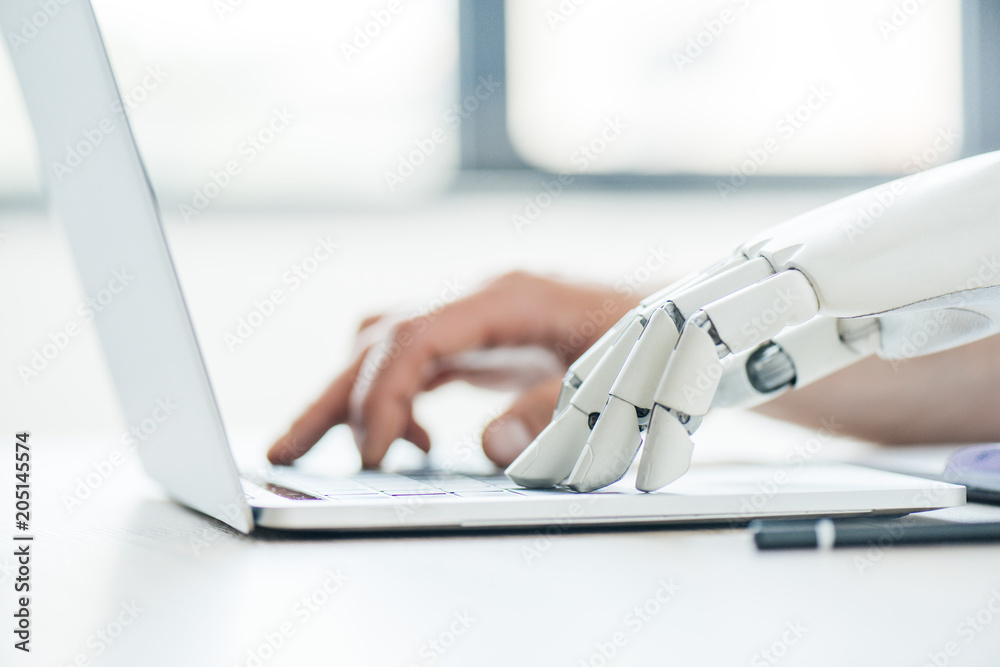 selective focus of human and robot hands typing on laptop at workplace - obrazy, fototapety, plakaty 