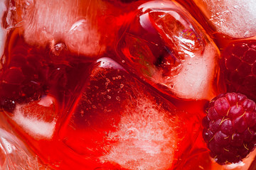 closeup photo of raspberries drink with ice . red macro food background