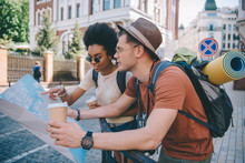 Multiethnic Couple Of Young Tourists With Map And Coffee Cups