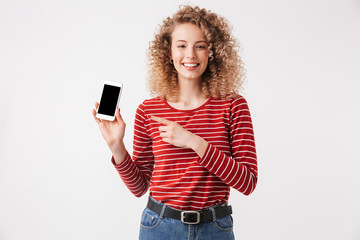 Poster - Smiling curly woman in casual clothes showing blank smartphone screen