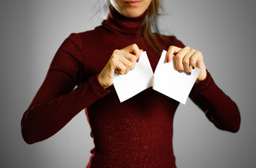 Wall Mural - Girl tearing a piece of paper in half blank white flyer brochure booklet. Leaflet presentation