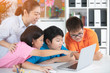 © sirikorn - Teacher and Cute Asian children using laptop computer together.