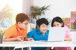 © sirikorn - Cute Asian children using laptop together.