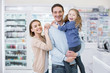 © zinkevych - Family together. Exuberant jolly family coming in drugstore and smiling to camera