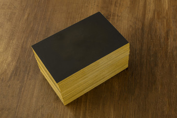 Wall Mural - Black business cards with golden endges mockup on a rustic background