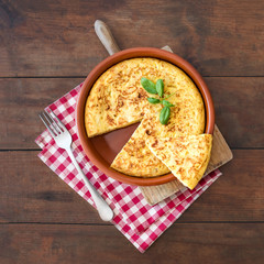 Wall Mural - Traditional spanish omelette close up,  view from above. Spanish tortilla on a rustic wooden texture with a place for text.