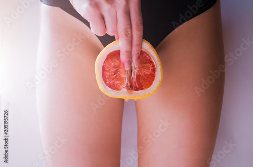 Fotografía A woman is holding a grapefruit by her panties