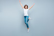 © deagreez - Portrait of active positive girl jumping with hands up raised leg isolated on grey background looking at camera enjoying summer time