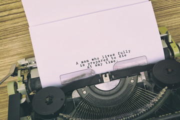 Motivational and inspirational life quote typed on vintage typewriter - A man who lives fully is prepared to die at any time.