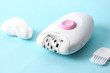 modern epilator on a colored background. minimalism. skin care, removal of unwanted hair.