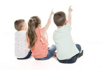 Back view of child group sitting on floor looking at wall