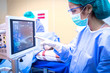 Female surgeon using monitor in operating room.