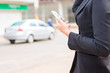 © Chayanin Wongpracha - Close up Businesswoman holding mobile phone while waiting for a city bus.