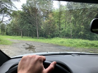 driving in tuscany rural street with hand on wheel