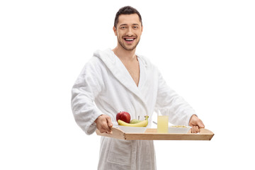 Wall Mural - Young man in a bathrobe holding a breakfast tray