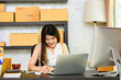 © livertoon - Asian charming beautiful girl entrepreneur planning project plan to note book after search information from laptop in modern working room. entrepreneurial self employed business concept.