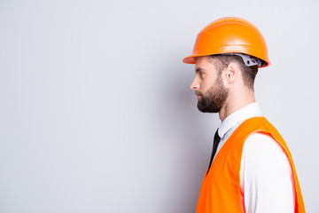 Profile portrait with copy space, empty place for advertisement of handsome calm man in hard hat uniform tie shirt isolated on grey background