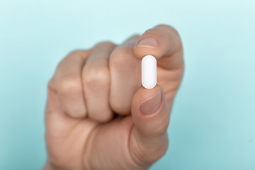 pill in man's hand on white background