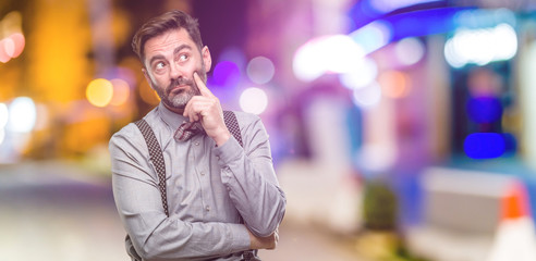 Sticker - Middle age man, with beard and bow tie thinking and looking up expressing doubt and wonder at night club