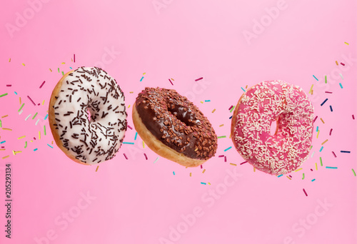 Fotografía Flying sweet donuts isolated on pink background.
