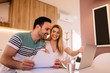 © Nebojsa - Happy young couple calculating bills at home