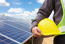 Young Business Man Engineer Hold Yellow Helmet At Solar Panel Power Plant Construction Site Background
